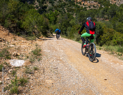 Group of mountain bikers practicing on a dirt track in a mountain.