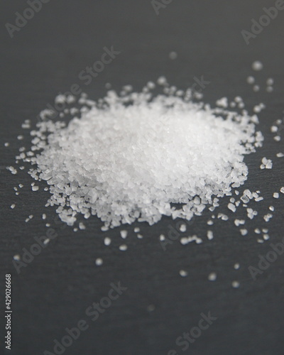 Salt, mineral consisting primarily of sodium chloride, on dark grey background