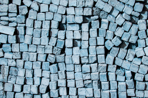 cobblestone piled in a heap. brick gray wall. dark unusual texture. blue geometric background
