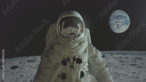 Apollo 11 astronaut on the moon surface with earth in the background.  photo