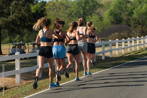 A group of athletic, young women go for a morning run.