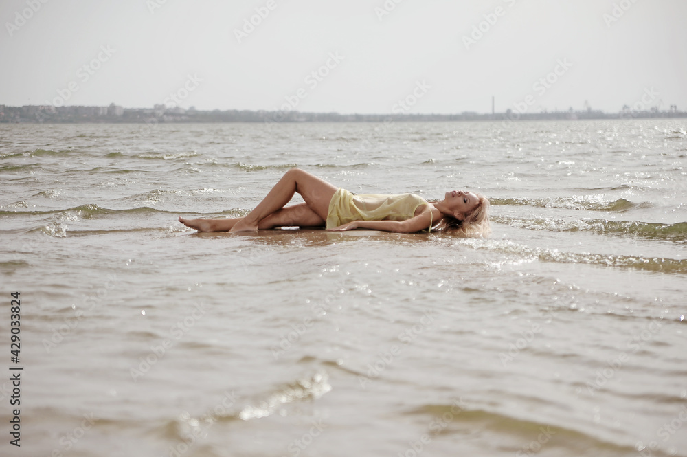 Beautiful blonde woman posing on the beach Beautiful blonde woman posing on the beach