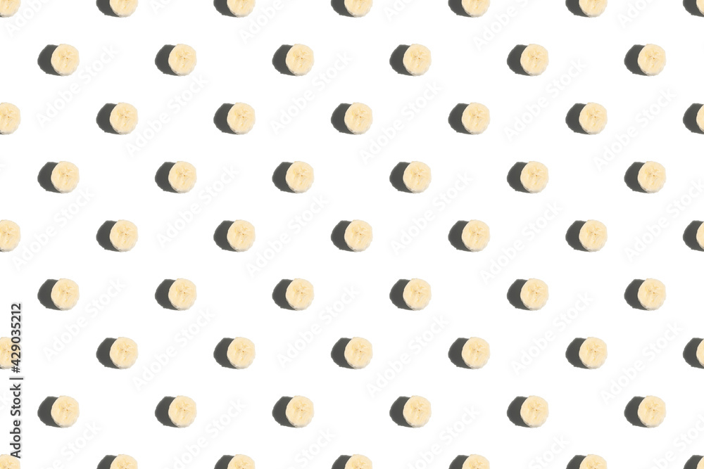 Banana slices on a white background. Seamless banana pattern. Hard shadows. Banana slices on a white background. Seamless banana pattern. Hard shadows.