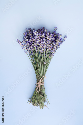 Flat lay lavender flowers in a bunch on a blue background vertical photo