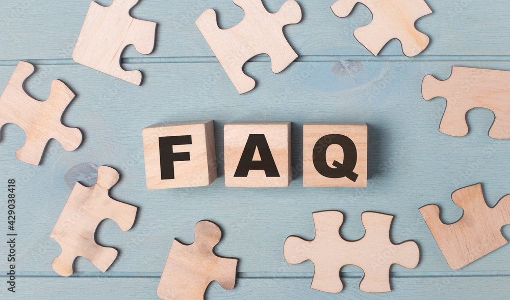 Blank puzzles and wooden cubes with the text FAQ lie on a light blue background. Blank puzzles and wooden cubes with the text FAQ lie on a light blue background.