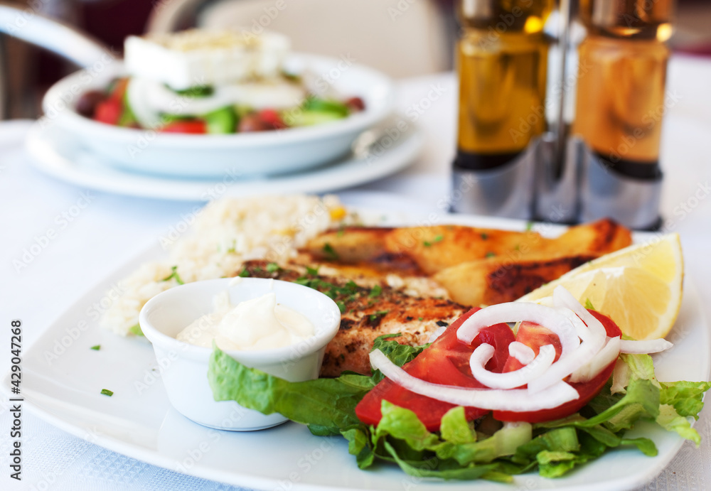 Greece food - Grilled salmon and vegetables on white plate