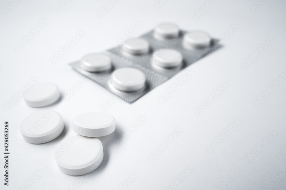 Pills on a white background. Coronavirus treatment, pandemic, quarantine. Isolated on white background, close-up, copy space.