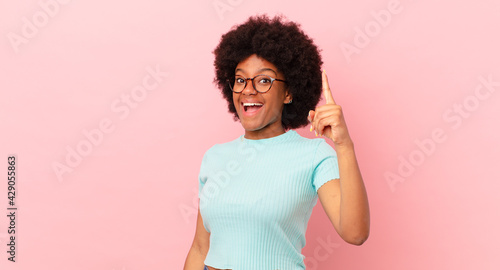 Konstfotografi afro black woman feeling like a happy and excited genius after realizing an idea