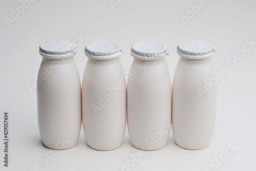 Natural liquid yogurt with probiotics in small plastic bottles on white background. Healthy, balanced diet food, healthy breakfast, dairy products. Selective soft focus, blurred background.