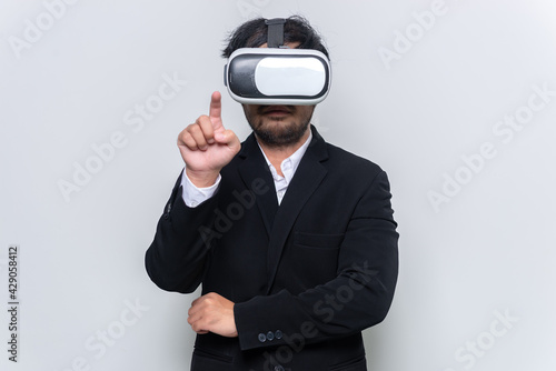 Portrait of young businessman wear virtual reality (VR) goggles on white background