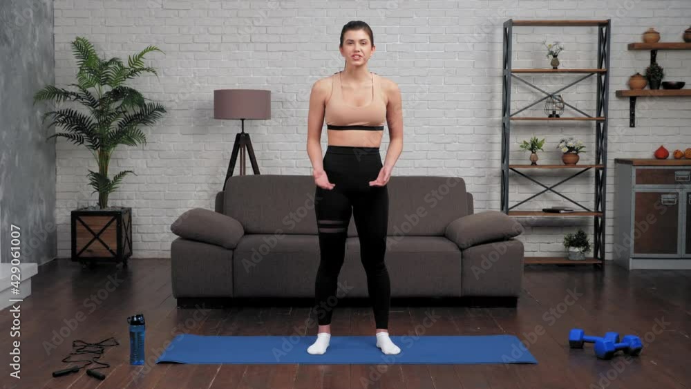 Young fit woman fitness trainer blogger greets waves hand teaches sports exercises tells listen student. Muscular girl athlete in sportswear records online webinar master class course, workout at home Young fit woman fitness trainer blogger greets waves hand teaches sports exercises tells listen student. Muscular girl athlete in sportswear records online webinar master class course, workout at home