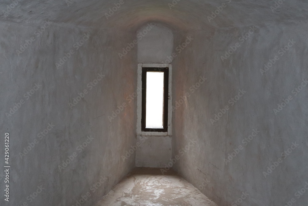 Narrow glazed window in the thick stone wall of the old castle