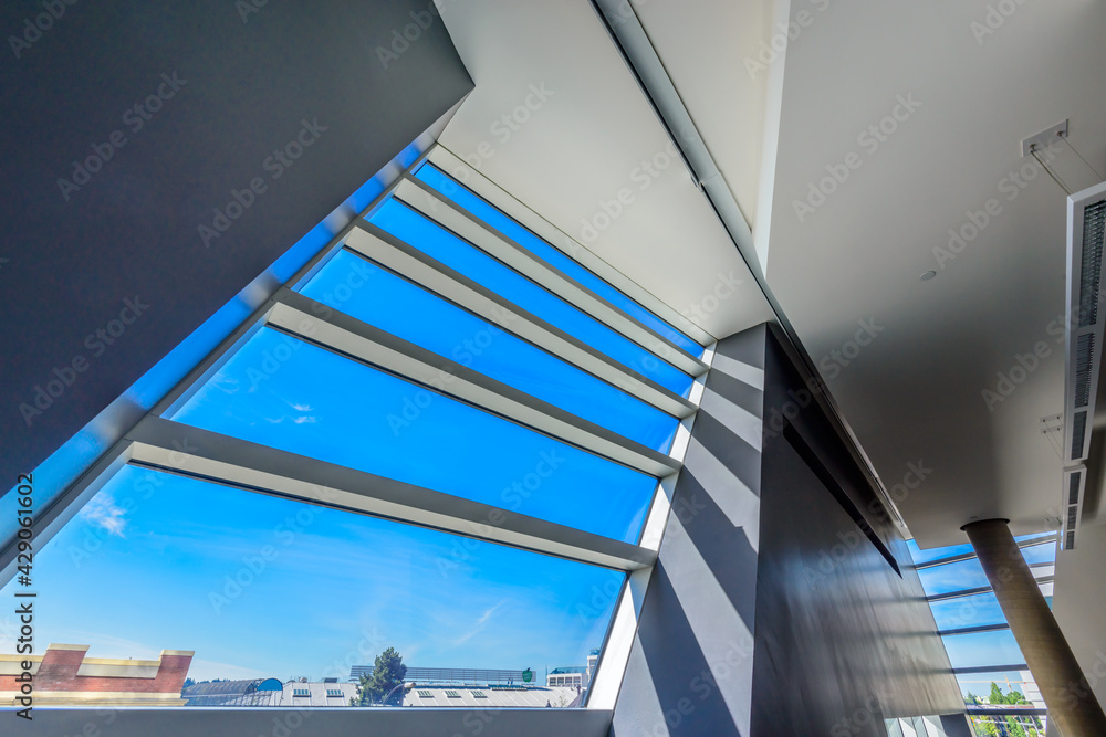 Obraz premium Window and blue sky. Abstract fragment of the architecture of modern lobby, hallway of the luxury hotel, shopping mall, business center in Vancouver, Canada. Interior design.