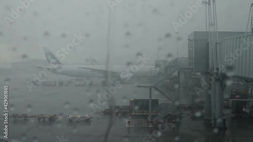 Delayed flight due to weather. Hurricane, fog and flood in the airport. Airplane waiting takeoff permission. Aircraft wing and plane window. photo