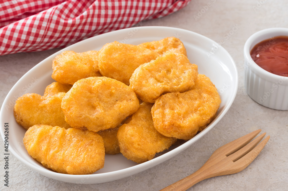 Chicken meat nuggets with ketchup sauce . Chicken meat nuggets with ketchup sauce .