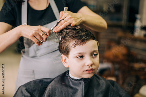 Haircut for little kid boy, professional barber doing haircut. Hairdress for children