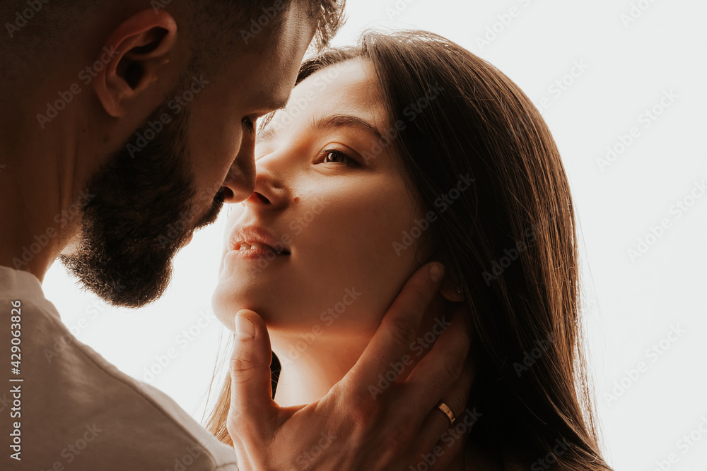 Image of young happy man kissing and hugging beautiful woman Image of young happy man kissing and hugging beautiful woman