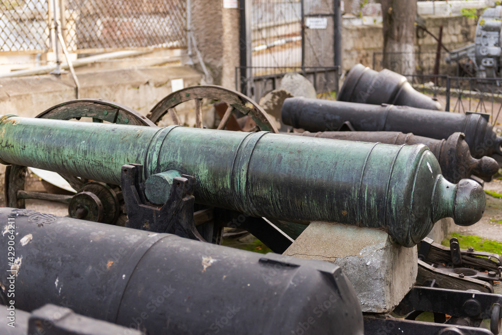 An old ship's cannon. Weapons on a pedestal at a historic building in Sevastopol.