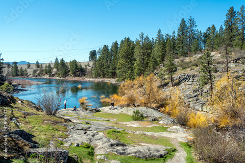Visitors enjoy an early Spring day at Falls Park, along the Spokane River and Dam in Post Falls, Idaho USA 