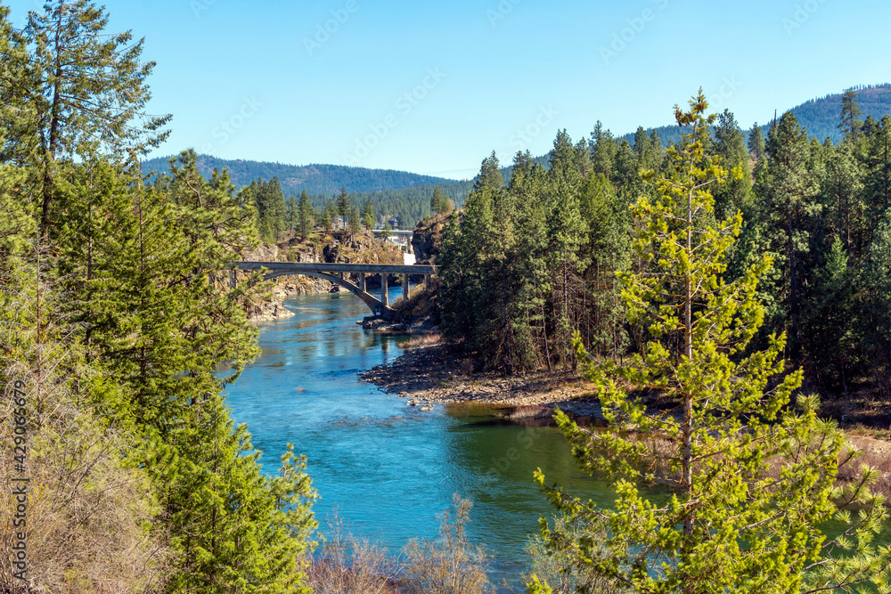 The Spokane River, falls and Avista Dam and bridge near Falls Park in the rural mountain community of Post Falls, Idaho, USA