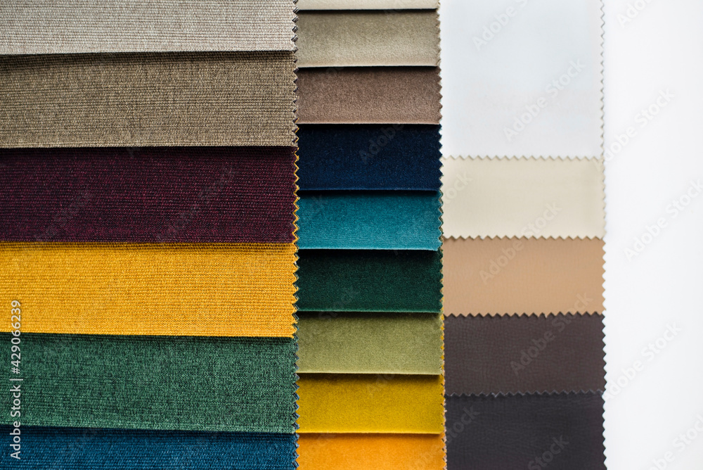 Fototapeta premium Catalog of fabrics to choose by texture and color for a new sofa, chairs in the living room, close-up