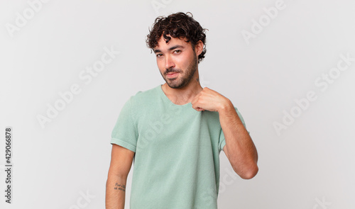 hispanic handsome man looking arrogant, successful, positive and proud, pointing to self