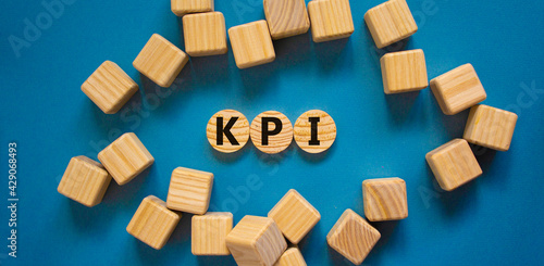 KPI, key performance indicator symbol. Wooden circles with word 'KPI, key performance indicator' on beautiful blue background, copy space. Business, KPI, key performance indicator concept.