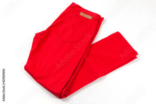 Red jeans pants isolated on white background. Folded casual style trousers 