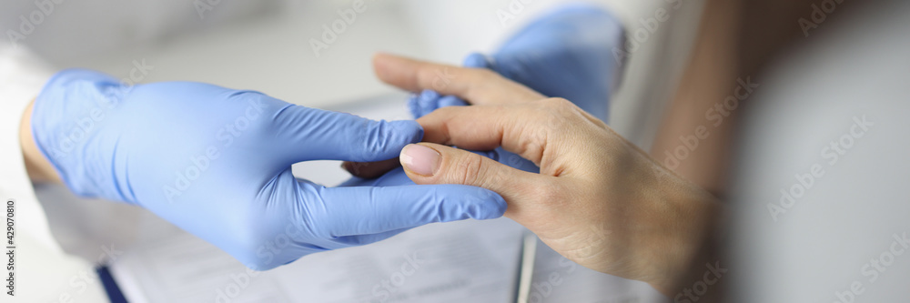 Doctor in gloves examines finger in a medical office