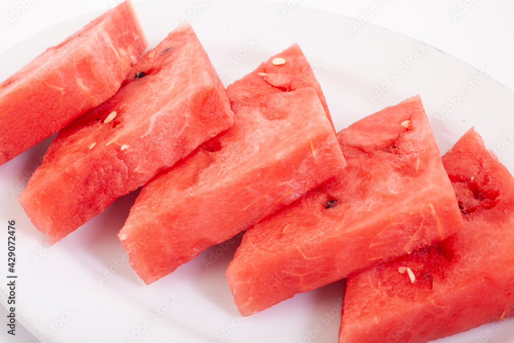 Triangle slices of fresh and juicy watermelon on white plate Triangle slices of fresh and juicy watermelon on white plate