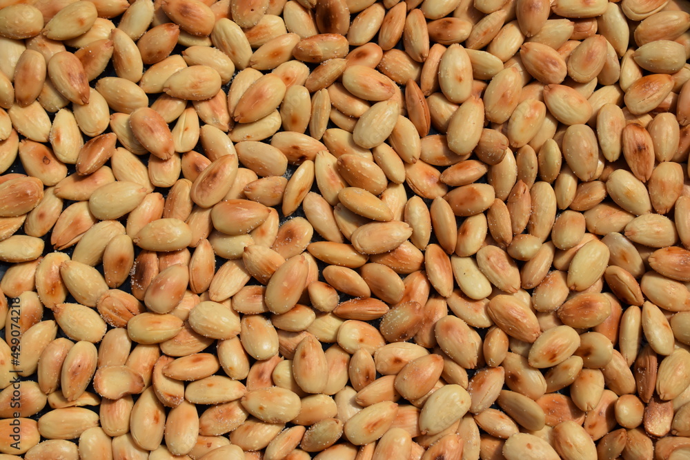 Freshly roasted almonds with salt background pattern Freshly roasted almonds with salt background pattern