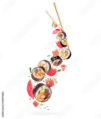 Fresh sushi rolls with various ingredients in the air on white background