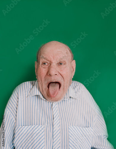 a large portrait of a crazy old man on an isolated green background. chromakey © Tatsiana