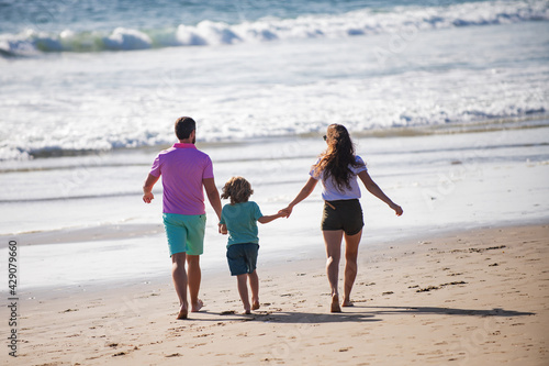Happy family running on beach at sunset. Family traveling concept. Summer holidays family.