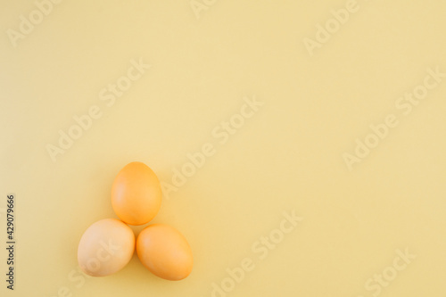 Minimalistic Easter composition with yellow Easter eggs on a yellow background. Copy space, top view, flat lay