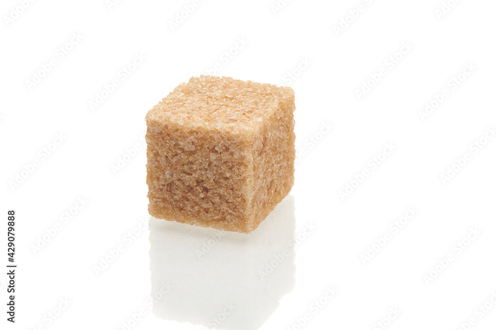 Brown cube of cane sugar isolated on white background. Close up view. Brown cube of cane sugar isolated on white background. Close up view.