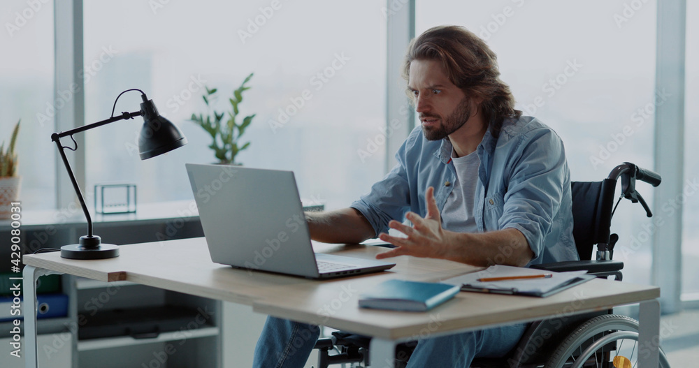 Depressed angry young man office worker losing computer data having problem internet connection screaming inside office corporate space. Emotions. Disabled person. Depressed angry young man office worker losing computer data having problem internet connection screaming inside office corporate space. Emotions. Disabled person.