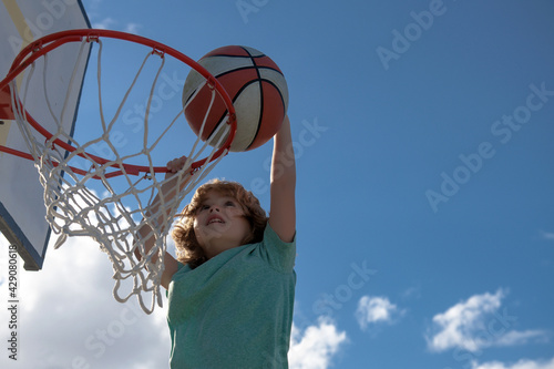 Basketball kid player running up and dunking the ball.
