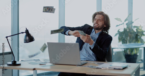 Quadro su tela Young excited rich businessman employee sitting in office celebrating payday financial holiday throwing money rain