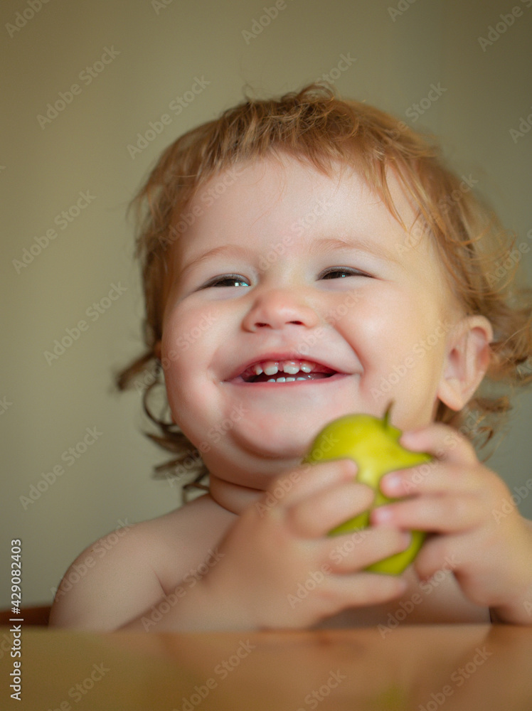 Laughing cute child eating apple fruit, portrait on blurred background. Enjoy eating moment. Healthy food and kid concept. Funny child face closeup. Laughing cute child eating apple fruit, portrait on blurred background. Enjoy eating moment. Healthy food and kid concept. Funny child face closeup.