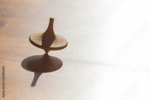 closeup of a spinning top symbolizing a fragile, unstable condition of balance achieved by constant movement like in the business world