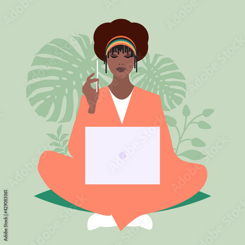African business woman sitting comfortably with a laptop and a pencil, surrounded by plants