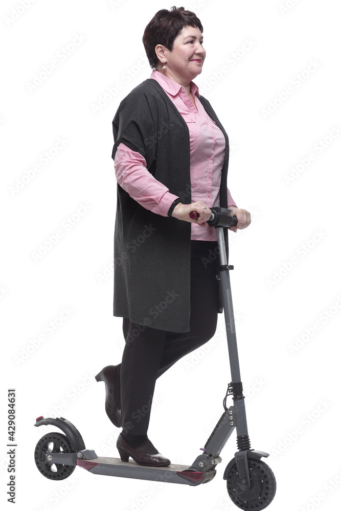 in full growth. confident mature woman with an electric scooter in full growth. confident mature woman with an electric scooter