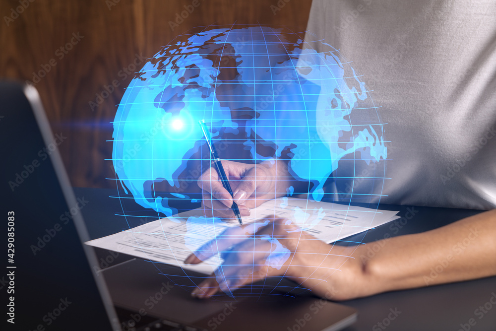 Businesswoman typing on laptop in office. Planet earth world map hologram. International business concept. Double exposure. Businesswoman typing on laptop in office. Planet earth world map hologram. International business concept. Double exposure.