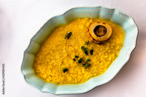 Fototapeta Yellow risotto alla milanese with saffron and bone marrow on a plate
