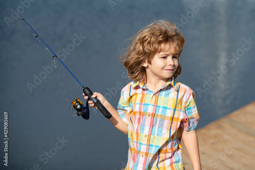 Young fisher. Child fishing at river bank, summer outdoor leisure activity. Little kid at river bank with rod. Angling.