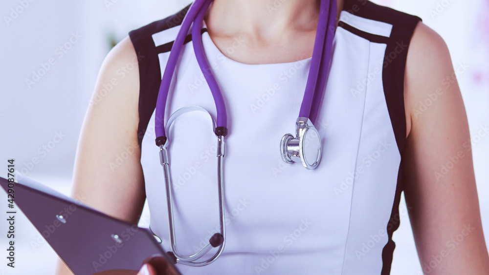 Portrait of friendly female doctor with stethoscope and tablet in hands. Portrait of friendly female doctor with stethoscope and tablet in hands.