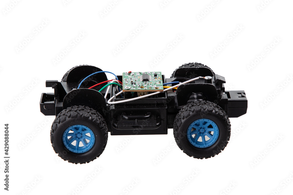 Broken radio-controlled toy car with electronic components on a white background Broken radio-controlled toy car with electronic components on a white background