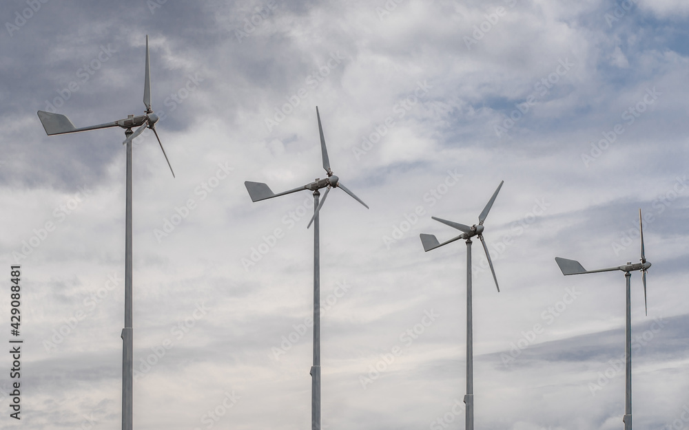 Four small wind turbines in the background of clouds. Environmentally friendly source of energy. Home power generation station. Four small wind turbines in the background of clouds. Environmentally friendly source of energy. Home power generation station.