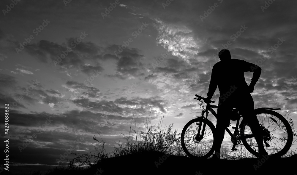 cyclist with a bicycle, on the black background .